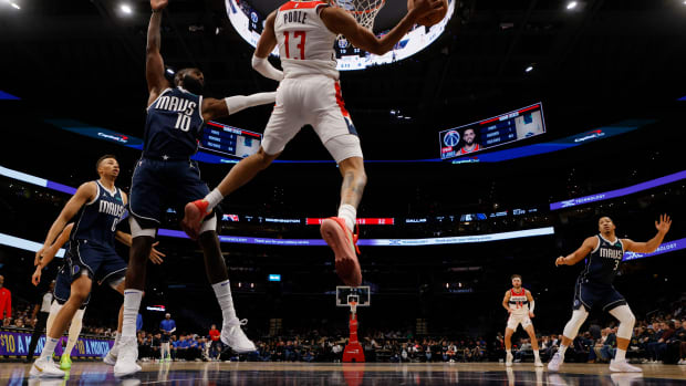 Nov 15, 2023; Washington, District of Columbia, USA; Washington Wizards guard Jordan Poole (13) leaps to pass the ball as Dallas Mavericks forward Tim Hardaway Jr. (10) defends in the first quarter at Capital One Arena. Mandatory Credit: Geoff Burke-USA TODAY Sports